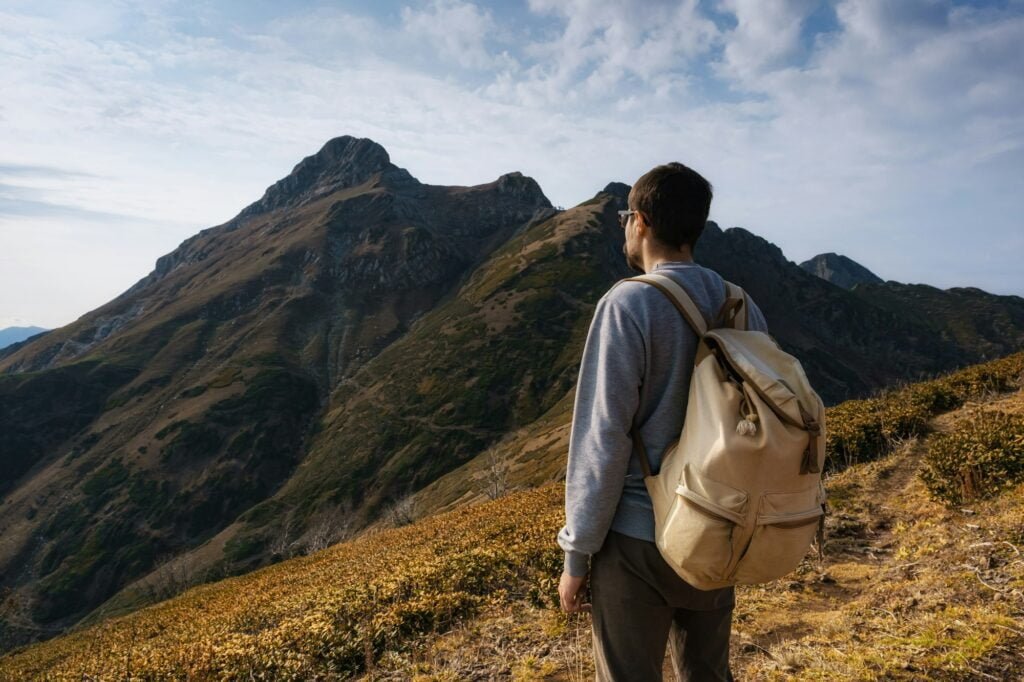 Young male hipster in the mountains in autumn